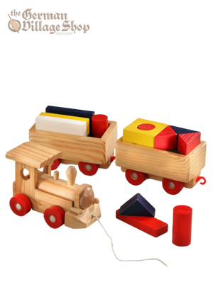 A pine wooden train with red wheels, pulls two rectangular carriages full of colourful building blocks.