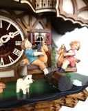 German Cuckoo Clock battery operated black forest chalet with see saw and music - close up of see saw