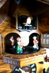 German Cuckoo Clock battery operated black forest chalet with wood sawyer men and music - close up of cuckoo bird