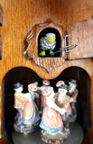 German Cuckoo Clock 8 day mechanical black forest chalet with moving bears and music - close up of cuckoo bird