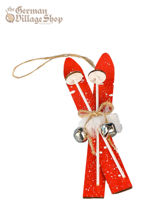 A pair of small red snow skis with faux fur and silver bells. Attached is a string to hang the skis as a Christmas Tree Decoration.