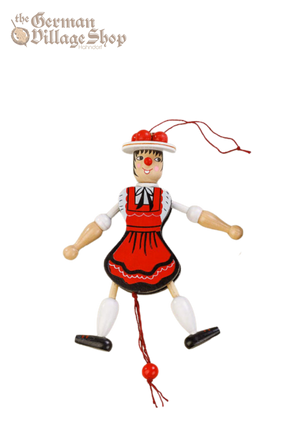 A jumping jack toy in the style of a female bavarian lady wearing a red and black dirndl dress. Pull the string and she jumps.