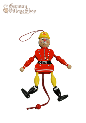 A jumping jack in red and yellow fireman's outfit. Pull the strings and his limbs jump.